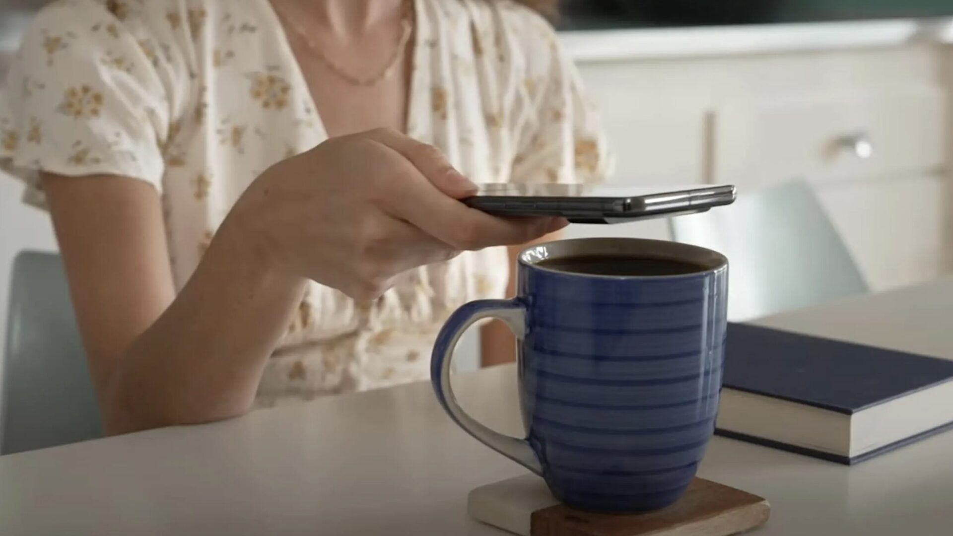 A woman measuring her coffee temp with a Pixel Pro Temp sensor.
