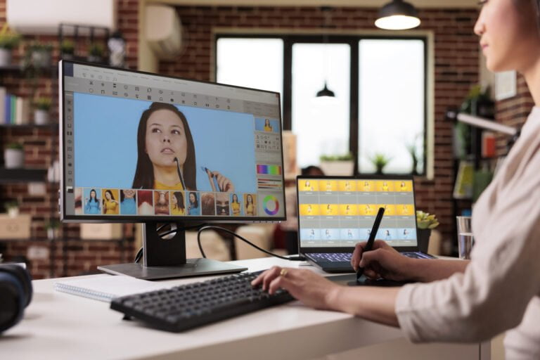 Asian photographer editing picture with retouching software on computer.
