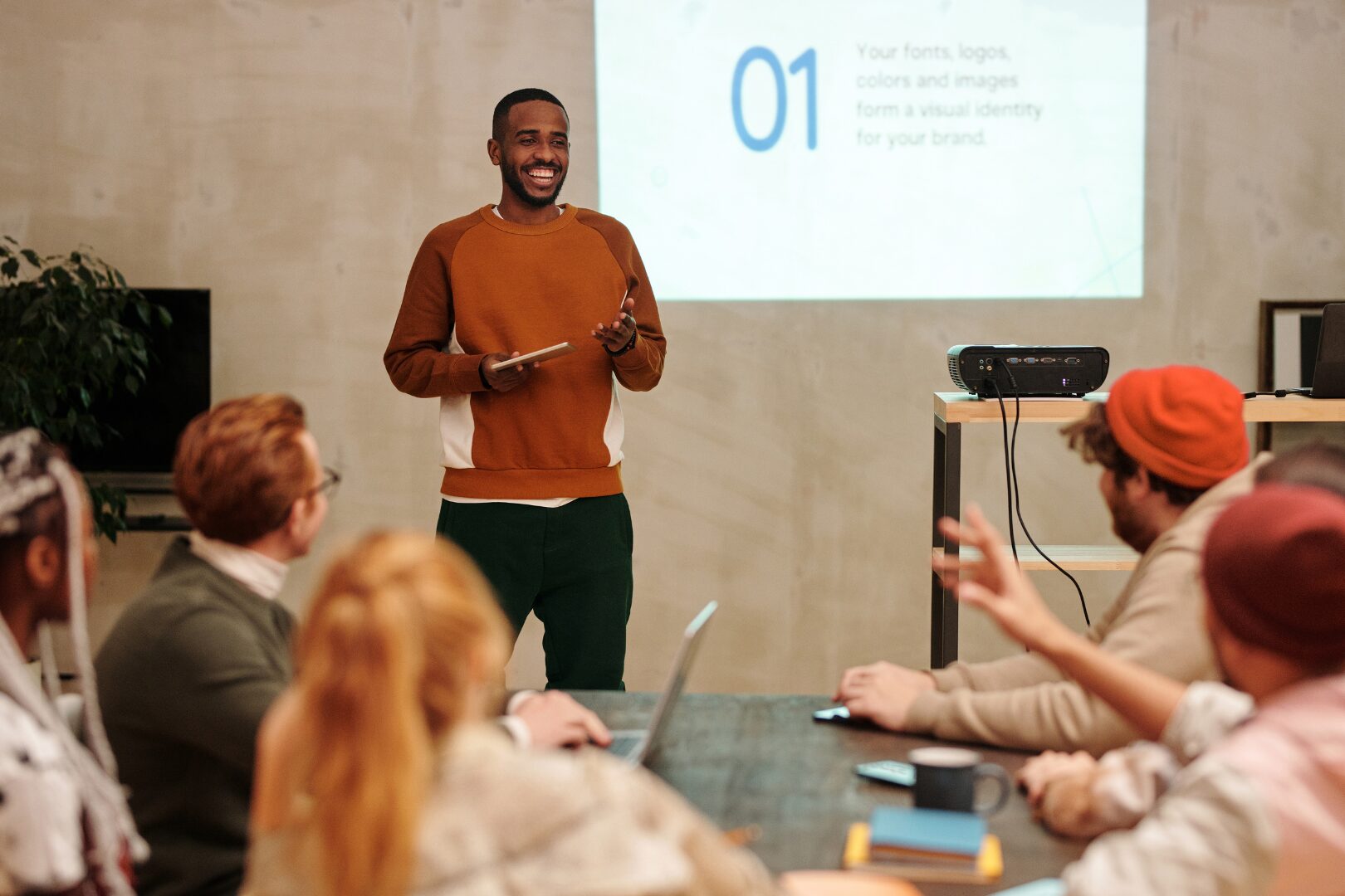 A man holding a presentation i front of his coworkers.