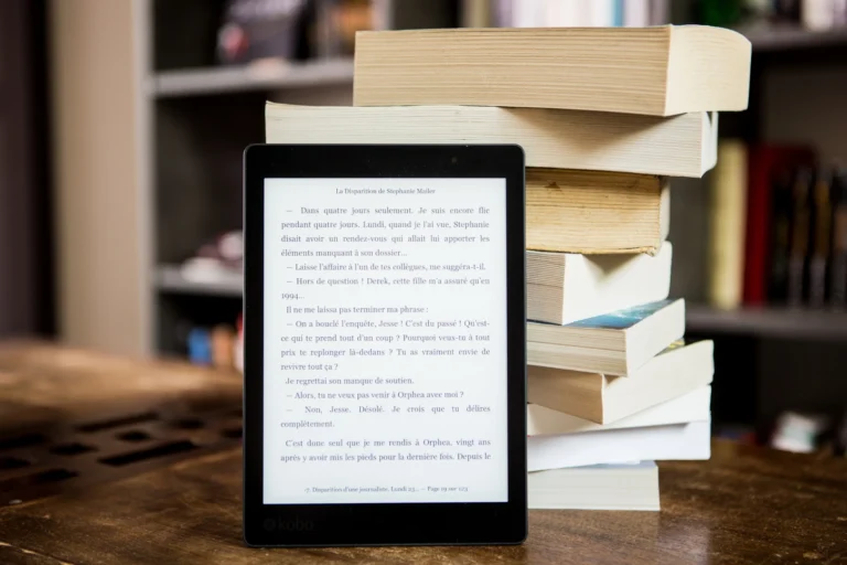 An eBook reader in front of books.